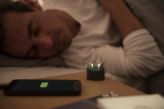 A man sleeps and leaves his rechargeable hearing aids charging