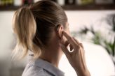 woman inserting RIC hearing aid