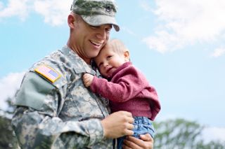 A soldier holding his daughter in his arms