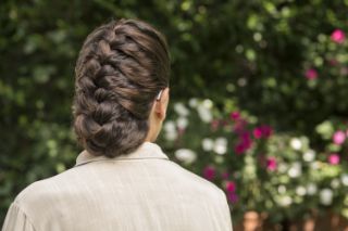 Una mujer en un jardín usando un audífono