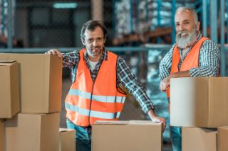 Two warehouse workers smiling
