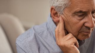 A senior man suffering from an ear condition