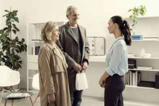 A senior couple talking with an Amplifon hearing professional in an Amplifon center