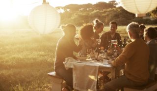 A family gathered around a table for a picnic outside