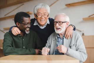 Three senior men smiling and laughing together