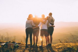 Group of friends facing the sun enjoying a view
